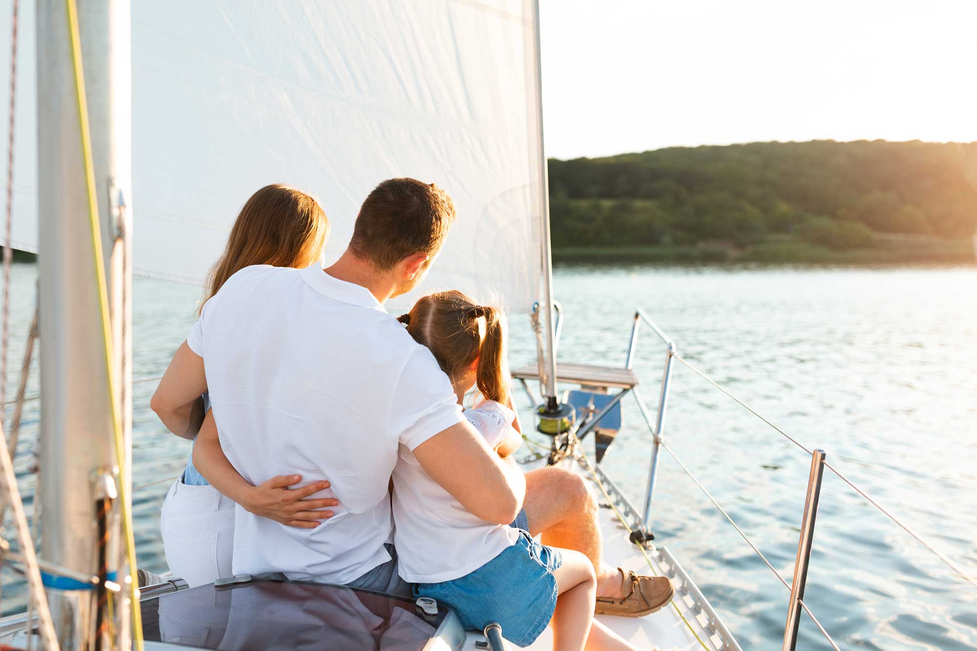 family-enjoying-yacht-tour-sitting-on-deck-sailing-in-sea